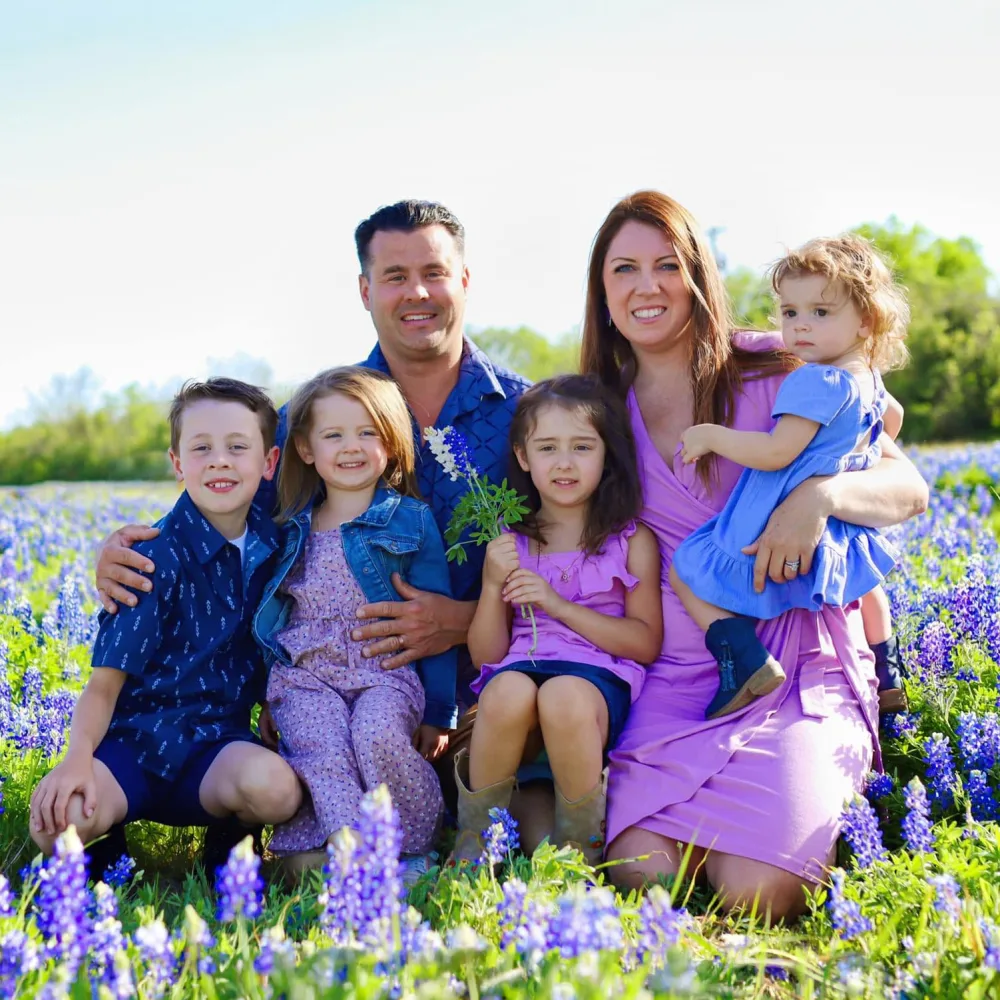 Josh Francois, founder of Ally Renewal, with his wife and four children in a Texas bluebonnet field